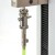 Miniature Film & Paper Peel Grip attached to mount holding half a Post-it 